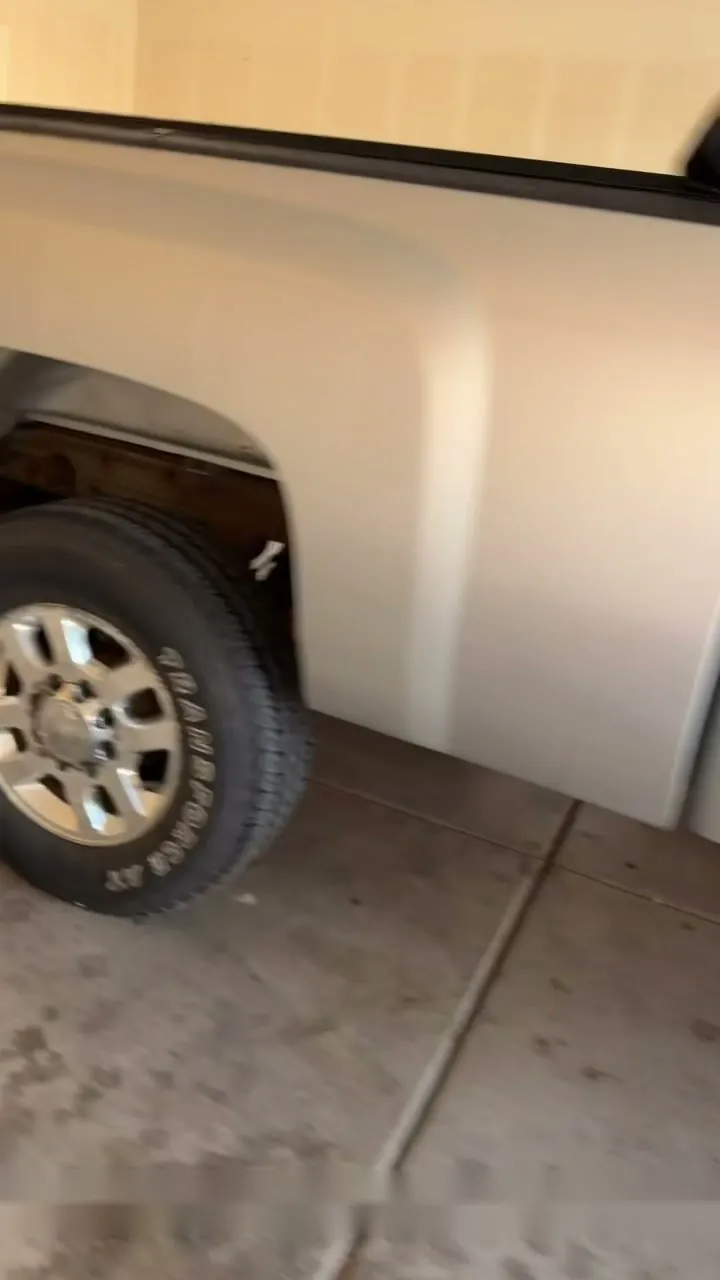 The clean rear fender and wheel of a gray Chevy pickup