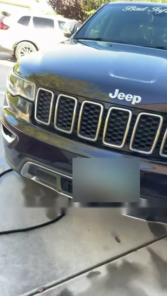 The clean front grille and hood of a black Jeep after a PMV Detailing wash