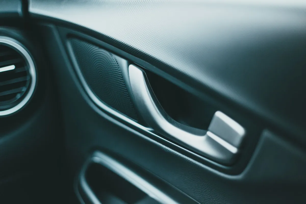 A clean dark door panel, handle and vent