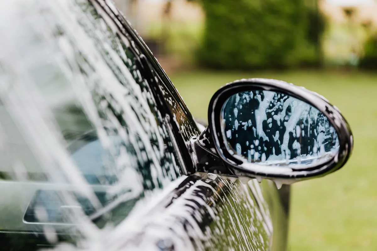 Foam on a black car's window and side mirror