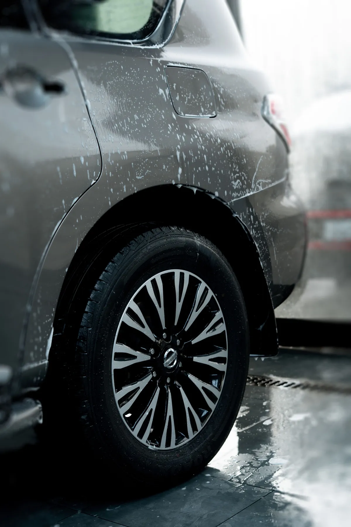 A rinsed silver wheel and tire, still wet