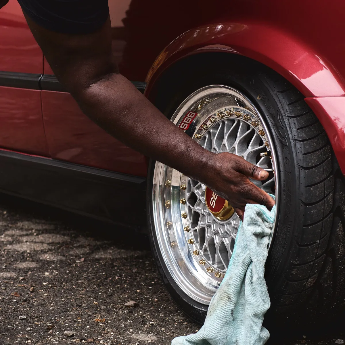 A towel drying a polished multi-spoke wheel